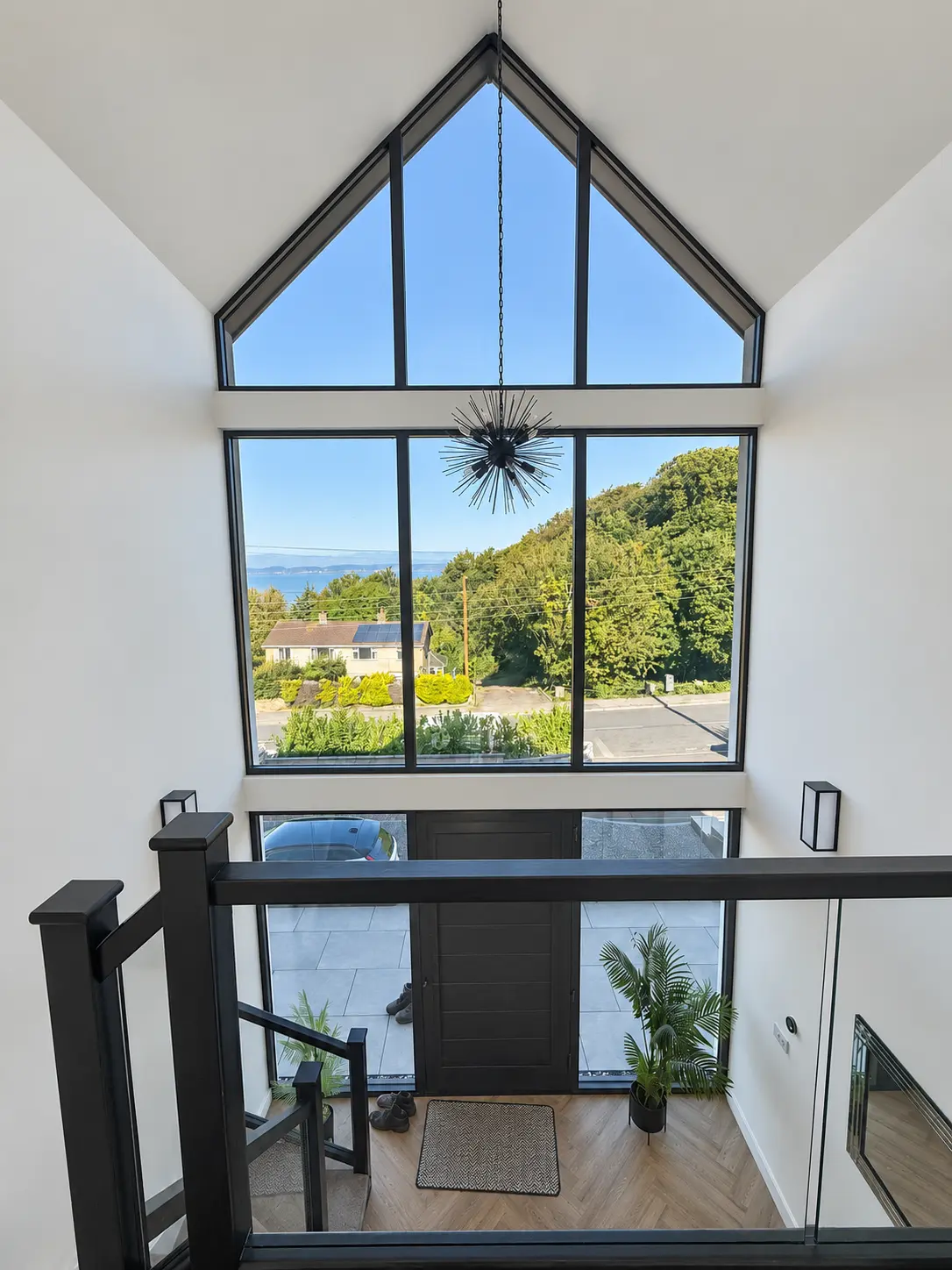 Interior view of a double-height stairwell through full-height aluminium gable glazing